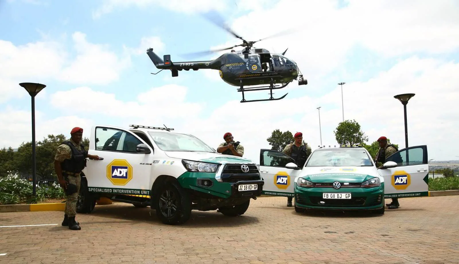 A composite image showing the Fidelity ADT branch office in Randhart, Alberton, on the left, with its distinctive green and white signage. The right side features a white Fidelity ADT tactical helicopter (Bell 206 series) with blue and yellow branding, landed on a grass field.